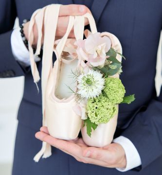 marié qui tient des chaussons de danse fleuris pour un mariage danse classique