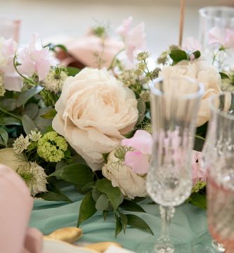 guirlande de fleurs rose pastel et blanc sur une table de mariage